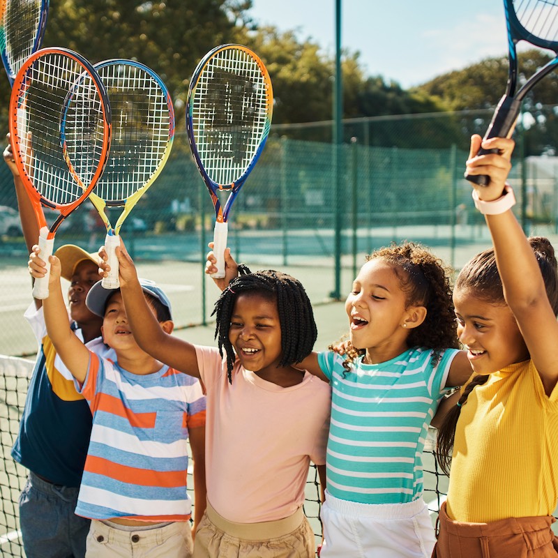 5 young players cheering at the tennis court